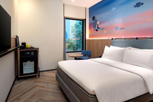 a hotel room with a large bed and a window at ibis Styles Semarang Simpang Lima in Semarang