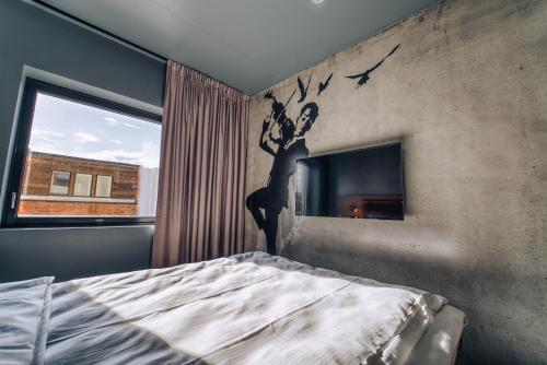Smarthotel Bodø في بودو: غرفة نوم مع لوحة جدارية لامرأة على الحائط