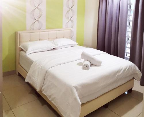 Una cama blanca con dos toallas encima. en Lee Majestic Condo Ipoh 6-8pax, en Ipoh