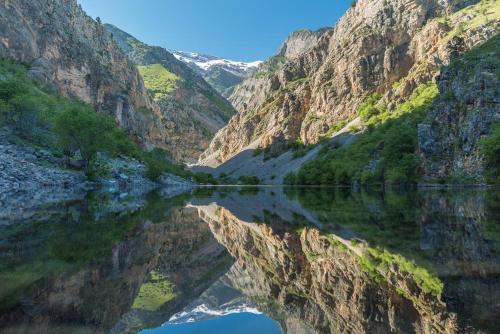 a mountain reflecting in the water of a canyon at Зона отдых APACHI в горах ЧИМГАН in Chimgan
