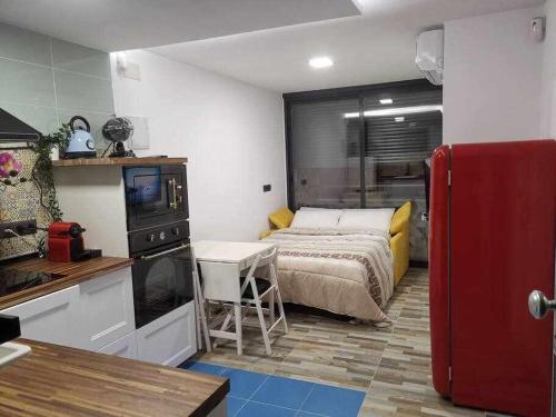 - une chambre avec un lit et un réfrigérateur rouge dans l'établissement Centro Torremolinos Apto 1 hab 1-4 personas WiFi Terraza, à Torremolinos