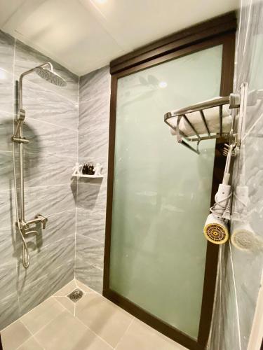 a bathroom with a shower with a glass door at Bông Villa Hotel & Apartment in Kon Tum