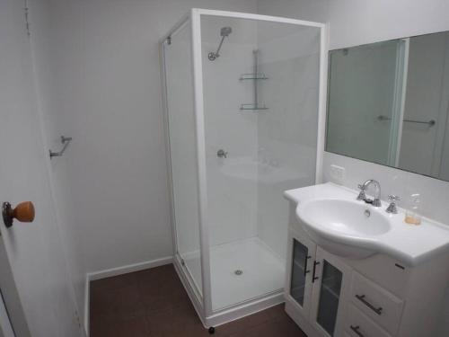 a white bathroom with a sink and a shower at Burnie Port Views in Burnie