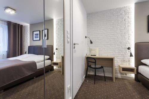 a hotel room with a bed and a desk and a bed at Hotel Czarna Róża in Toruń