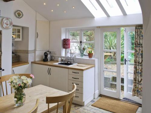 a kitchen with a table and a dining room at Lavender Cottage in Methwold