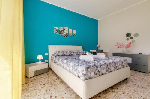 a bedroom with a bed and a blue wall at Cherry Blossom - Affitti Brevi Italia in Palermo