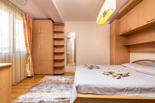 a bedroom with a bed and wooden cabinets at Centrally-located 1BD Apartment near Kapana in Plovdiv