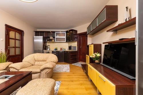 sala de estar con 2 sillas y TV de pantalla plana en Centrally-located 1BD Apartment near Kapana, en Plovdiv