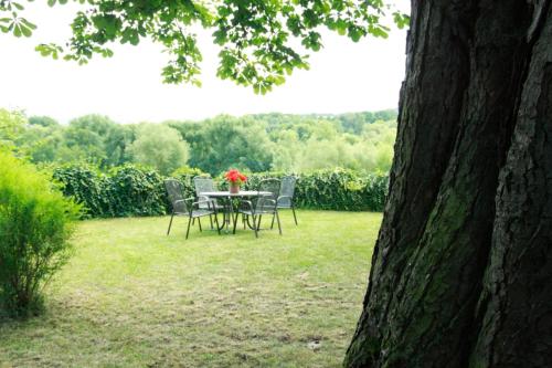 a table and chairs in a yard with a table and flowers at wohnen auf dem Weingut - klein und fein - Wengertssube in Maring-Noviand
