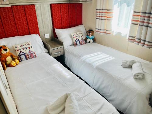 two beds in a room with two teddy bears at The best views on site. Haven Reighton Sands Filey in Reighton