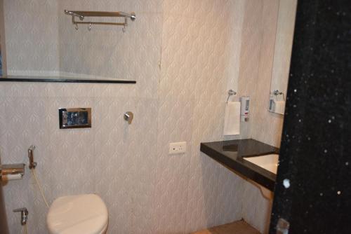 a bathroom with a toilet and a sink at TGN SUITES - HOTEL in Raipur