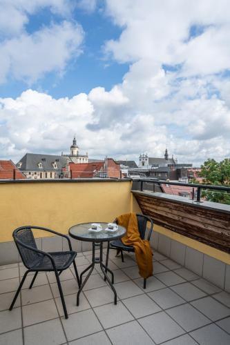 a table and chairs on a balcony with a view at LeoApart in Wrocław