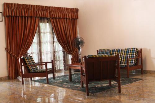 a living room with two chairs and a table at Natures Bliss Holidays in Ja-Ela