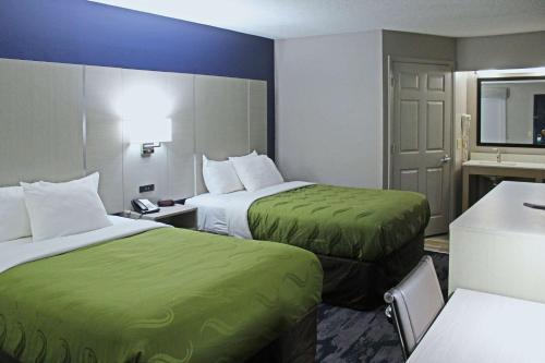 Cette chambre d'hôtel comprend 2 lits avec des draps verts. dans l'établissement Quality Inn Scottsboro US/72-Lake Guntersville Area, à Scottsboro