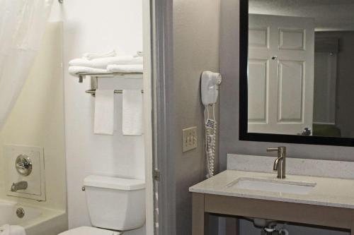 La salle de bains est pourvue de toilettes, d'un lavabo et d'un miroir. dans l'établissement Quality Inn Scottsboro US/72-Lake Guntersville Area, à Scottsboro