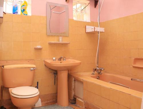 een badkamer met een toilet, een wastafel en een bad bij Nyahururu Highlands Heaven -BnB in Nyahururu