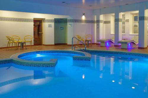 une grande piscine avec des chaises et une table dans l'établissement Barton Manor Hotel & Spa; BW Signature Collection, à Preston