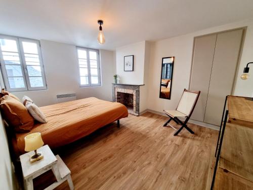 une chambre avec un lit et une cheminée dans l'établissement Maison très agréable et calme avec terrasse en centre ville, à Angoulême
