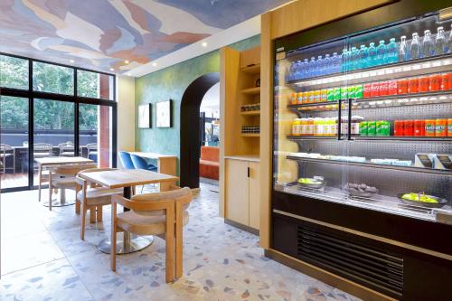 a restaurant with a fireplace and tables and chairs at Hyatt House Johannesburg Rosebank in Johannesburg