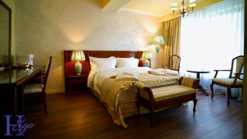 a bedroom with a large bed and a desk and a window at HEgo in Hunedoara