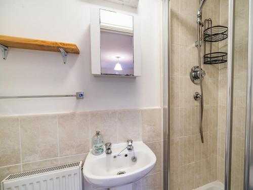 uma casa de banho com um lavatório e um chuveiro em Monument Way em Ulverston