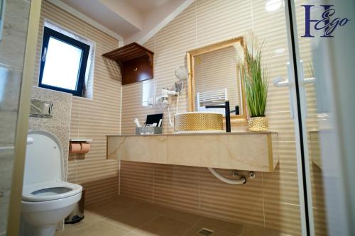 a bathroom with a toilet and a sink and a mirror at HEgo in Hunedoara