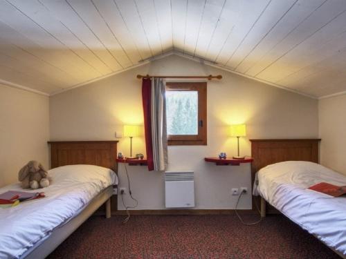 Cette chambre comprend 2 lits, une fenêtre et 2 lampes. dans l'établissement Residence La Marelle et Le Rami - maeva Home, à Les Coches