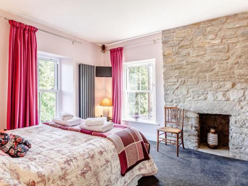 a bedroom with a bed and a stone wall at Claysun House in Whitecroft