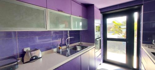 ラ・オリーバにあるSand Volcano Villa 2の紫色のキッチン(シンク付)、窓