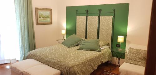 a bedroom with a bed with a green headboard at DeiMori LaMassa private villa with pool in Castel San Niccolò