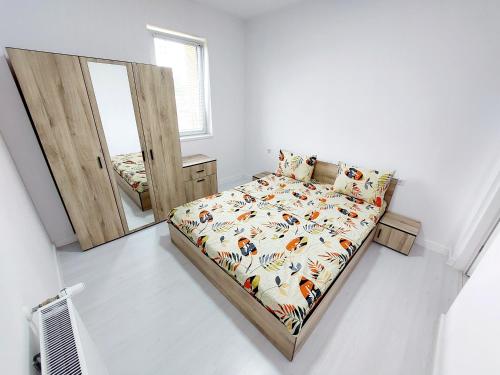 a small bedroom with a bed and a mirror at Casuta cu Tei in Oradea