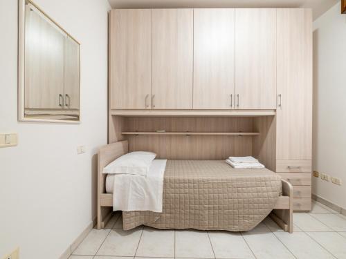1 dormitorio con 1 cama y armarios de madera en Ca' Mastro Bright Flat with parking, en Tavullia