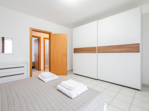 Habitación blanca con 2 toallas blancas en el suelo en Ca' Mastro Bright Flat with parking, en Tavullia