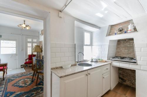 a white kitchen with a sink and a counter at Iconic Stone Houses in Izmir