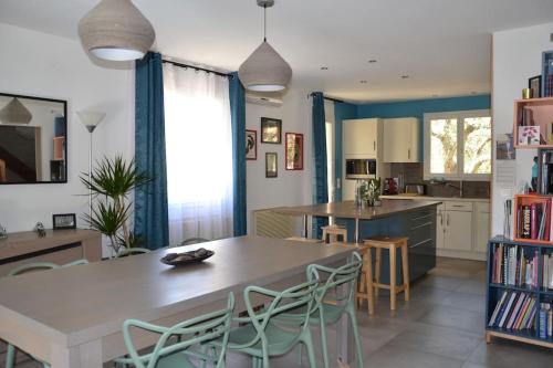a kitchen with a table and chairs in a room at Jolie Villa, Piscine, 10min centre ville, WIFI in Montpellier