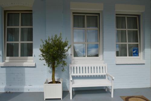 a white bench and a tree in front of a house at Landhaus Hamm in Düsseldorf