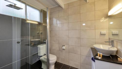 uma casa de banho com um WC, um lavatório e um chuveiro em Azalea Motel em Coonabarabran