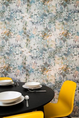 a dining table with yellow chairs and a wall at LeoApart in Wrocław