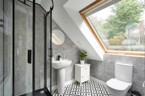 a bathroom with a toilet and a sink and a window at Blaisedell House by Cliftonvalley Apartments in Bristol