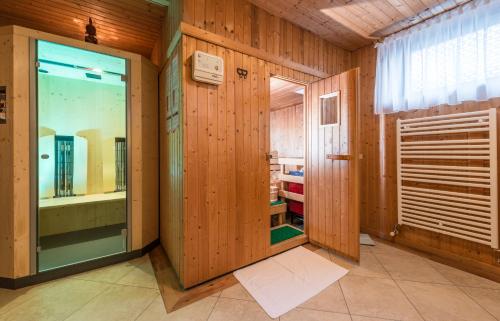 Habitación con paredes revestidas de madera y puerta de cristal. en Alpen Villa Rieder, en Filzmoos