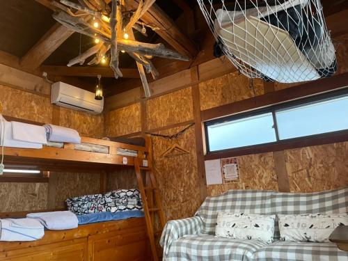 Zimmer mit 2 Etagenbetten und einer Decke in der Unterkunft GYPSY TAKASHIMA in Katsuno