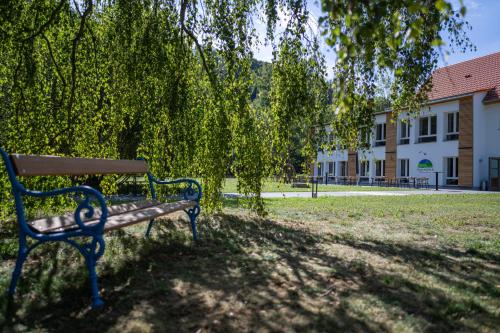 ławka w parku siedząca w cieniu drzewa w obiekcie Thalmühle w mieście Meisdorf
