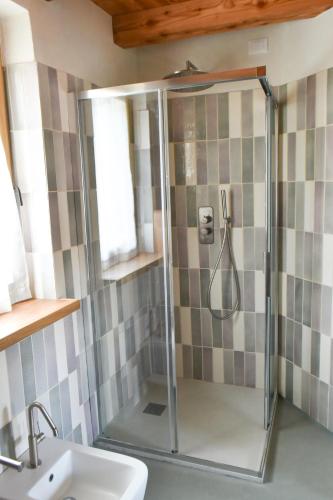 a shower with a glass door next to a sink at Casa Zefìra in Feltre