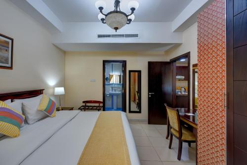 a bedroom with a large bed and a dining room at Al Hayat Hotel Apartments in Sharjah