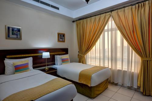 沙迦的住宿－奧哈亞特公寓酒店，酒店客房设有两张床和窗户。