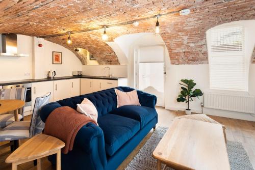 a living room with a blue couch and a kitchen at Redcliffe Parade No.9 I Your Apartment in Bristol