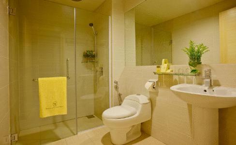 a bathroom with a toilet and a sink and a shower at Jinhold Apartment Hotel in Bintulu