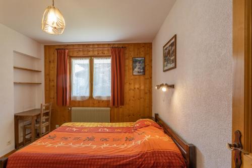 um quarto com uma cama, uma janela e uma mesa em Le petit chez soi em Châtel