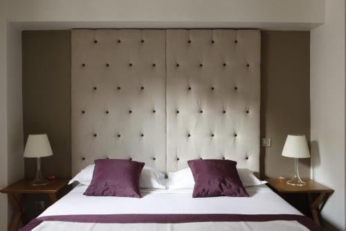 sypialnia z dużym łóżkiem z 2 fioletowymi poduszkami w obiekcie Windsor Opera w Paryżu