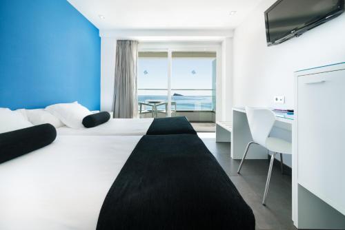 a hotel room with a bed and a view of the ocean at Hotel Brisa in Benidorm